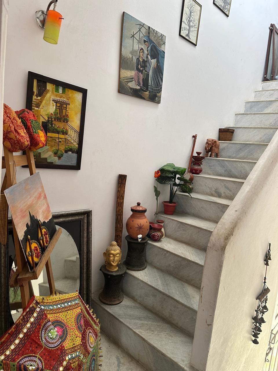 Staircase to terrace lined with paintings and artefacts